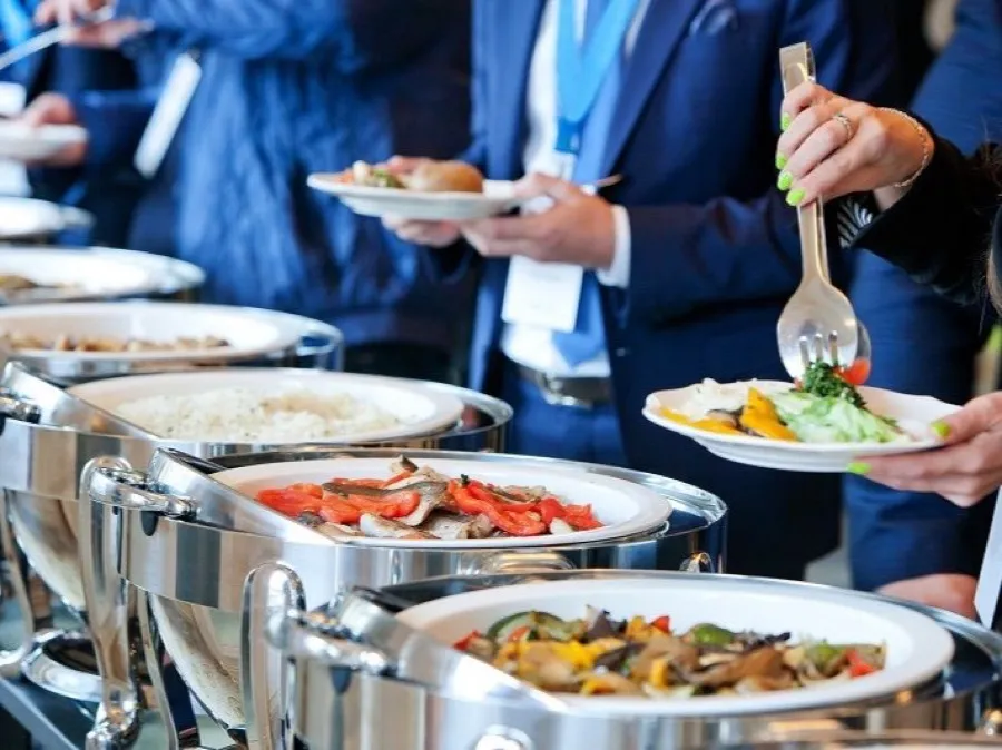 Guests in business attire serving themselves from a buffet at a corporate event
