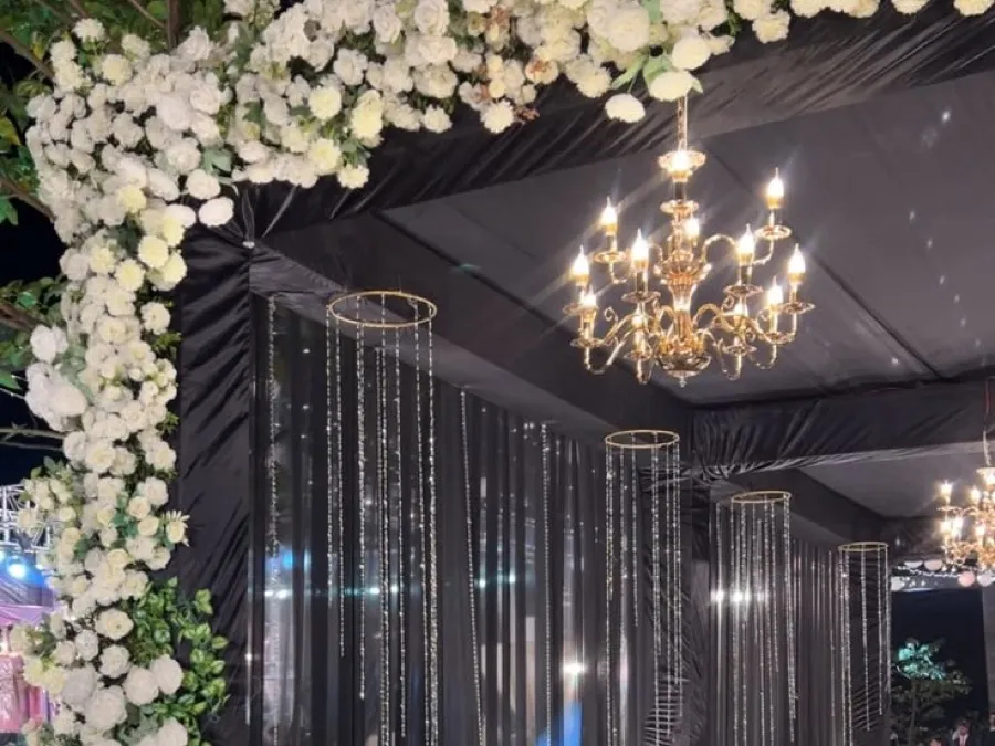 White floral arch and chandelier styling at an event entrance